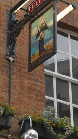 Vertical-Video-Of-Close-Up-Of-Sign-Outside-The-Iron-Duke-Pub-On-Avery-Row-In-Mayfair-London-UK